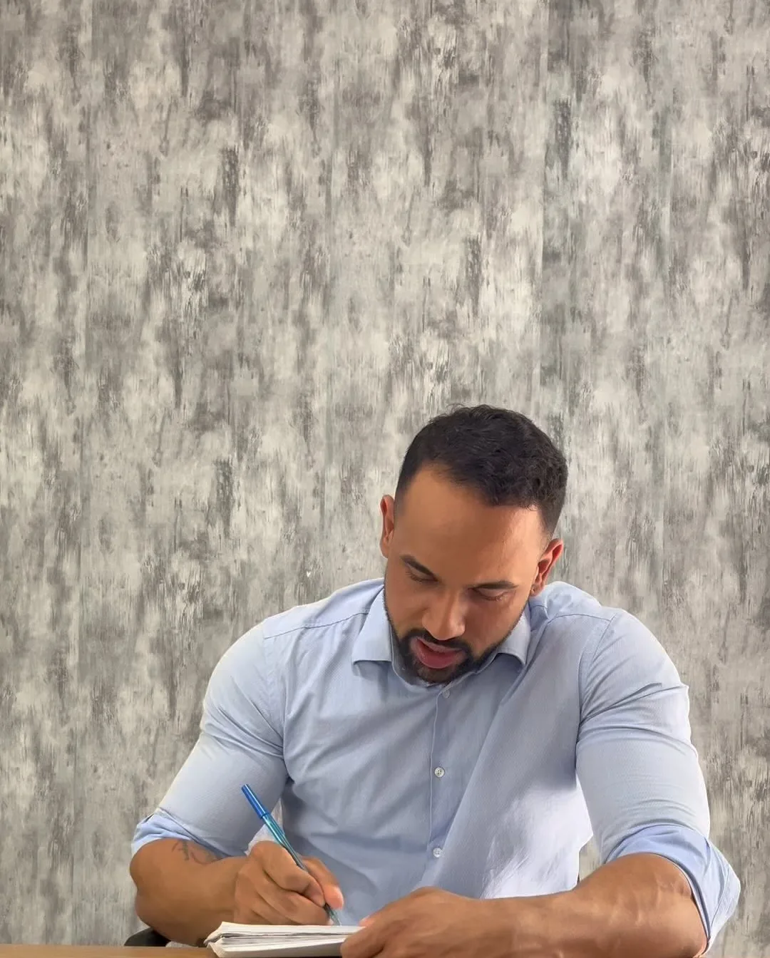 Franthesco Curbani escrevendo um plano na mesa do consultório