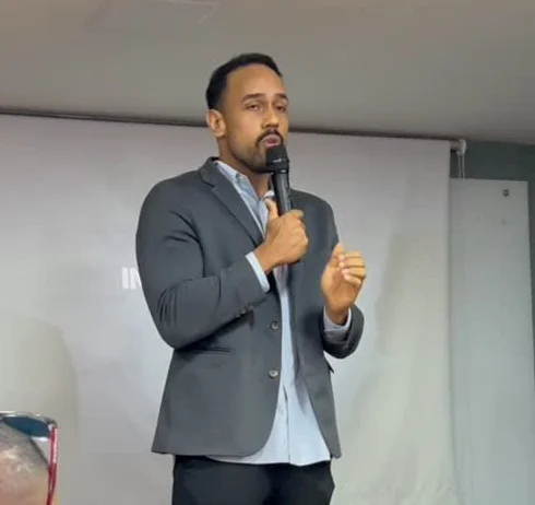 Franthesco Curbani de terno falando ao microfone para uma plateia de nutricionistas e personais